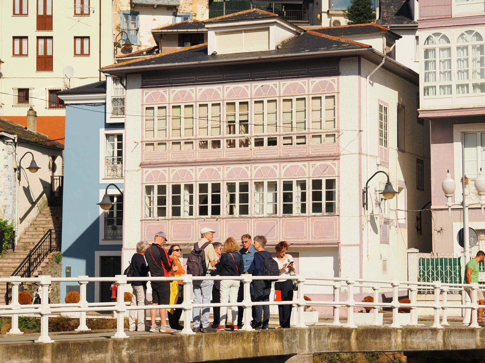 Fachada rosa de Luarca con grupo en el puente